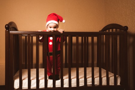 little boy chewing on her bed at homeの写真素材