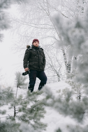 Male photographer taking pictures in winter environmentの写真素材