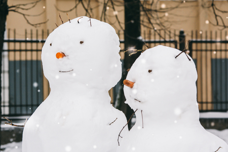 festive snowmen fashioned children standing in yardの写真素材