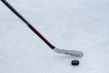 close-up stick and puck on the ice backgroundの写真素材