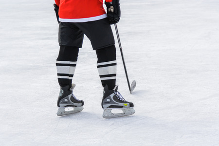 hockey skates standing on ice with hockey stickの写真素材