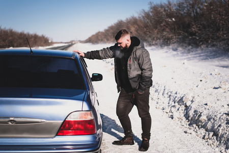 man stands near his broken car dayの写真素材