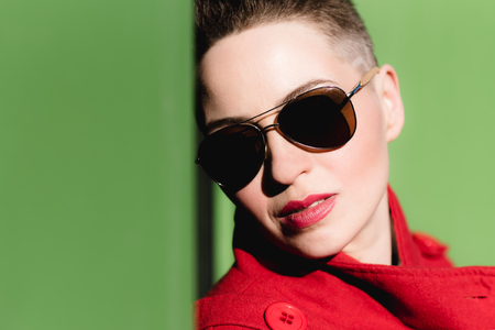 Girl in red posing on green backgroundの写真素材