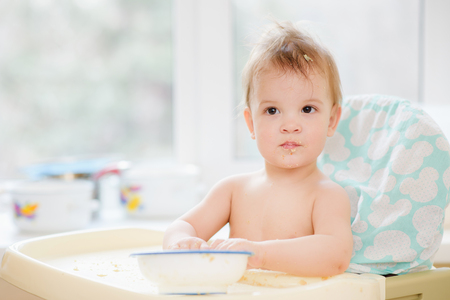 Kid plays in the kitchen with dishesの写真素材
