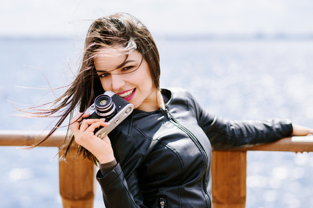 Attractive girl takes pictures with an old camera の写真素材