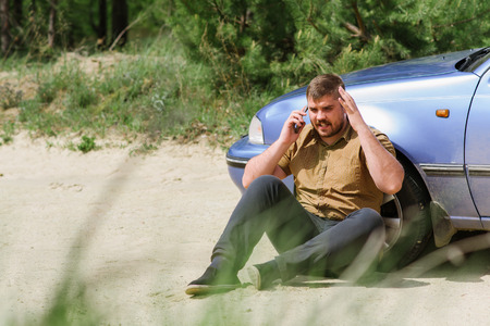 Alarmed driver calls the help desk by phoneの写真素材