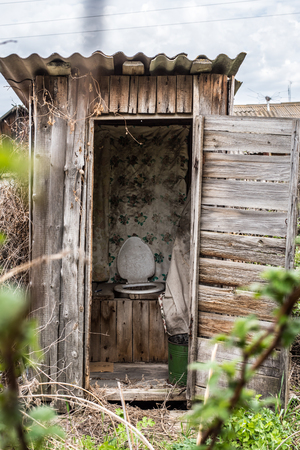 Old wooden rotting toilet in the yardの写真素材