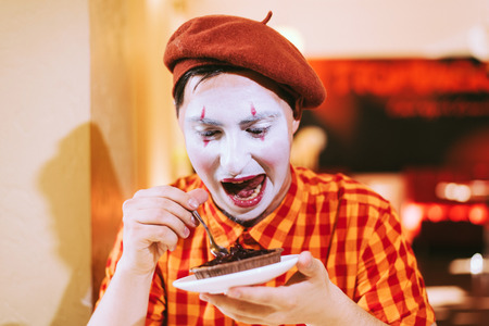 Mime eats cake in a cafe and croaks a faceの写真素材