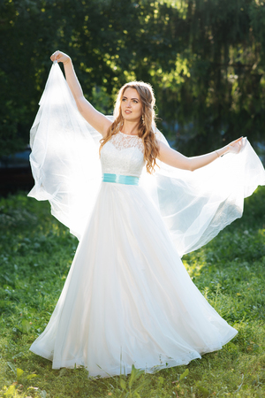 beautiful bride posing for the photographer on the natureの写真素材