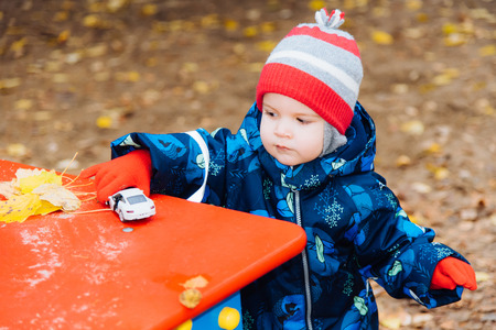the child plays cars on the street