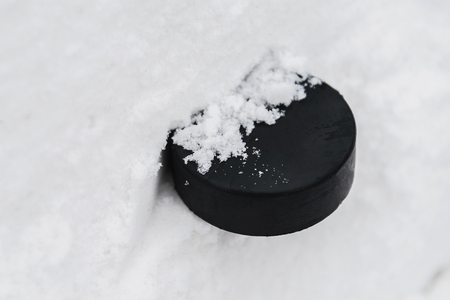 hockey puck lies on the snow macroの写真素材