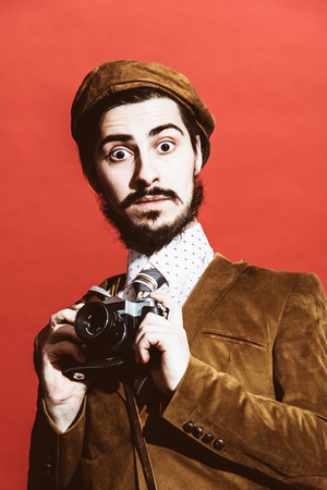 very positive photographer posing in studio with cameraの写真素材