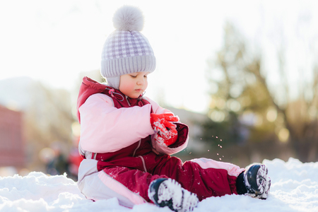 little kid plays in the street in winterの写真素材