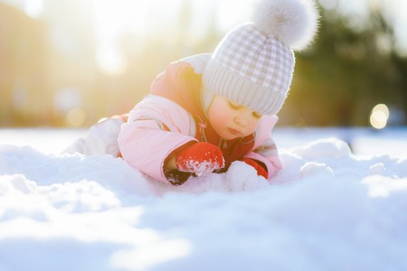 little kid plays in the street in winterの写真素材