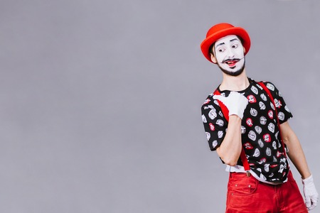 cheerful mime posing near a gray backgroundの写真素材