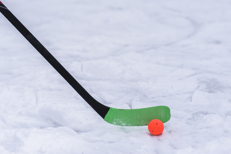Green stick and orange ball for hockey