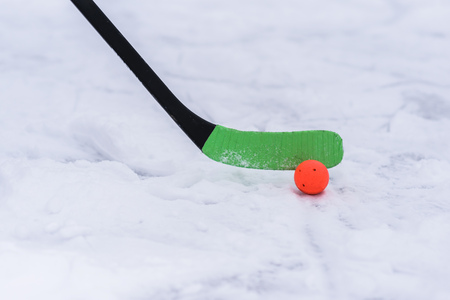 Green stick and orange ball for hockey