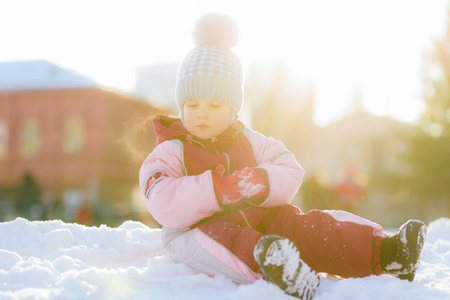 little kid plays in the street in winterの写真素材