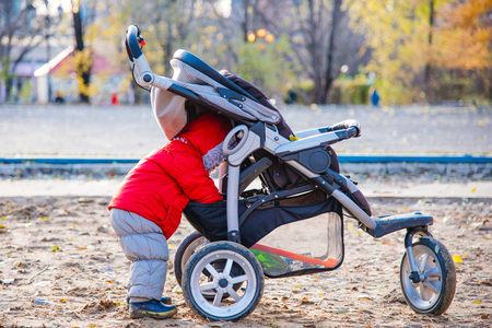 little kid looking in the stroller his toysの写真素材