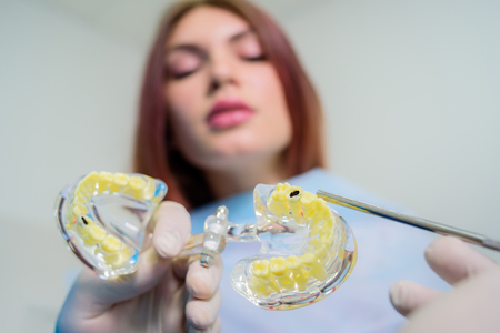 The orthodontist shows the carious cavity in the patient's chewing tooth