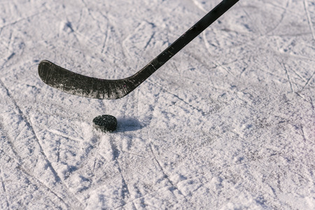 close-up stick and puck on the ice background