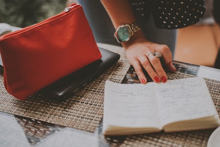 A businesswoman writing something in a notebookの写真素材
