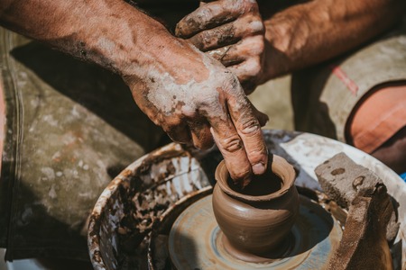 Master hands makes a pot of clay. The master class is held in nature.の写真素材