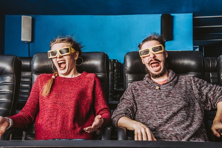 the couple is very worried while watching a movie in the cinema