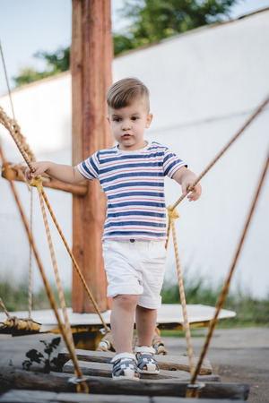 a little boy plays in a rope town, and overcomes an obstacleの写真素材