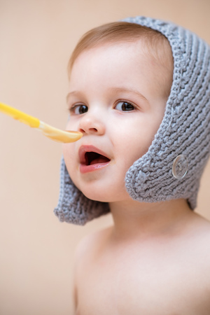 Mom feeds the baby with fruit puree at home