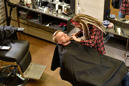 woman hairdresser does the hair to a brutal man in the salonの写真素材