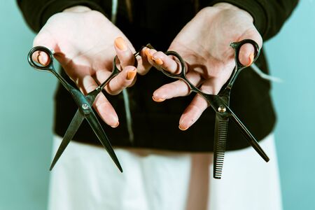 woman hairdresser holding scissors in hands close-upの写真素材