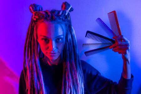 beautiful woman with dreadlocks holding a comb in her hand