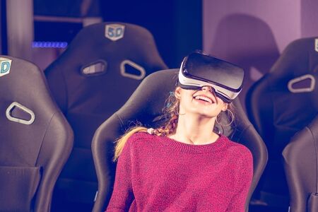 beautiful girl in virtual glasses is watching a movie with special effects