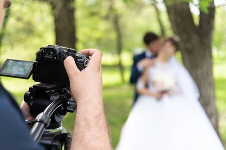 The videographer shootes the marrieds in the garden in the summer.の写真素材