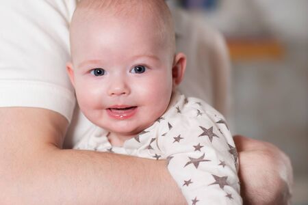 Dad holds his son in his arms. Father spends time with a newborn baby.Close-up