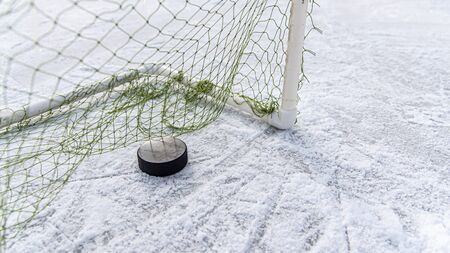 Hockey puck in goal at the stadiumの写真素材