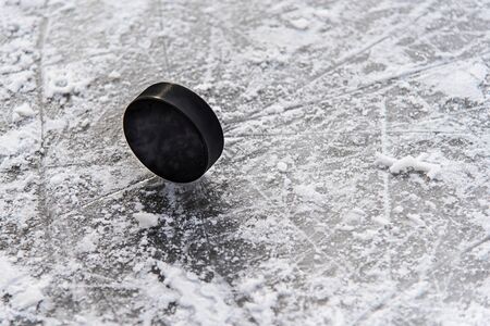 hockey puck lies on the snow macroの写真素材