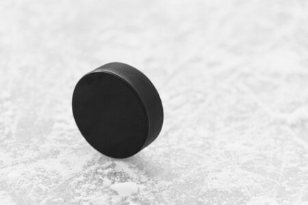 hockey puck lies on the snow macro