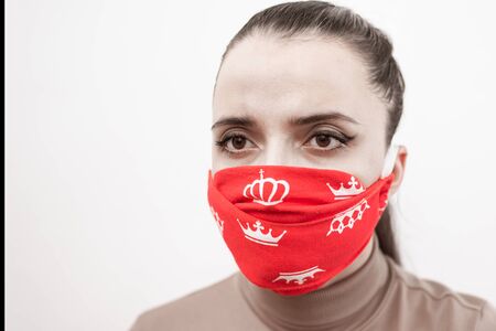 Closeup of a woman in a protective red mask with crowns. Prevention of coronavirus and Covid -19 during a global pandemicの写真素材