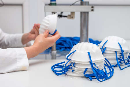 A woman works in a factory for the manufacture of medical masks with nanofibre and solder loops with...