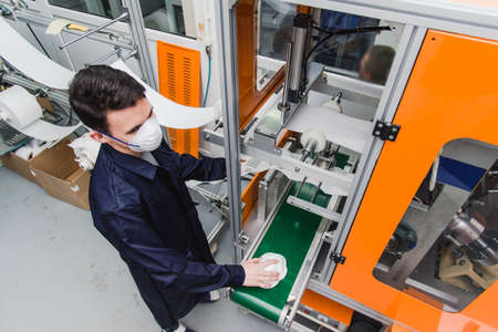 The guy works in a factory for the manufacture of medical masks with nanofiber. Coronovirus and...