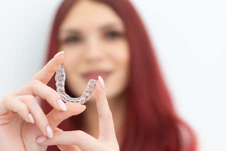 Girl with a beautiful smile shows a transparent mouth guardの写真素材
