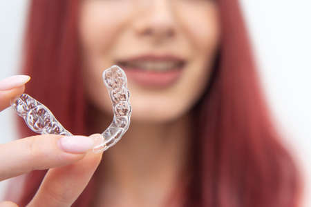 Girl with a beautiful smile shows a transparent mouth guard