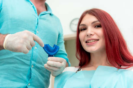 Doctor orthodontist shows the patient the result of the casts of her teeth