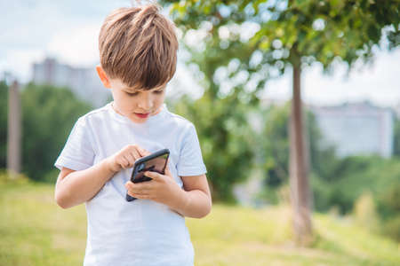 the child speaks on the phone in nature