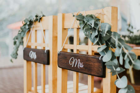 Chairs for bride and groom decorated with mr and mrs signs for wedding ceremonyの写真素材