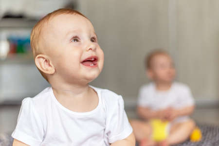 Cute baby laughing while sitting on the floorの写真素材
