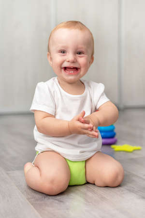 Happy child laughing while sitting on the floor