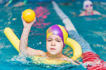 Small child swim in an indoor pool.の写真素材